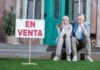 4 motivos por los que tu casa no se vende. Qué puede fallar en la venta de un inmueble. Fotografía de una pareja sentada a la puerta de su casa, con gesto de desánimo al no conseguir venderla.