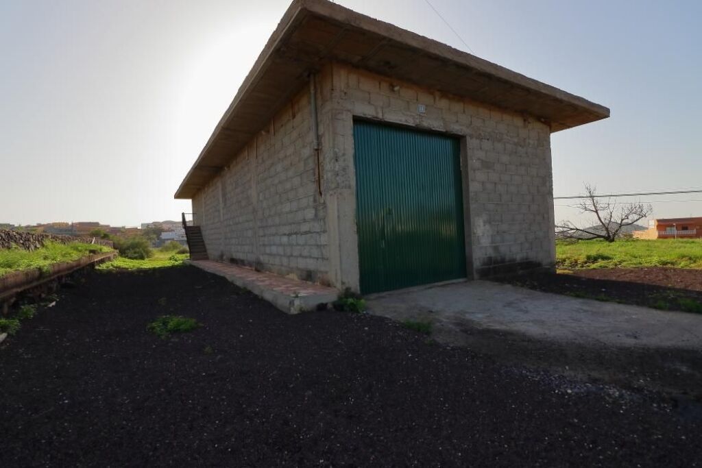 Almacén de 200 m2 con invernaderos y tanque de agua, terreno rústico con excelentes accesos en Arona