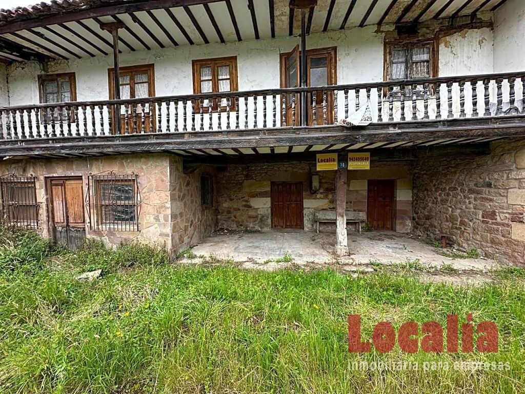 Foto casa de piedra de dos niveles con jardín.